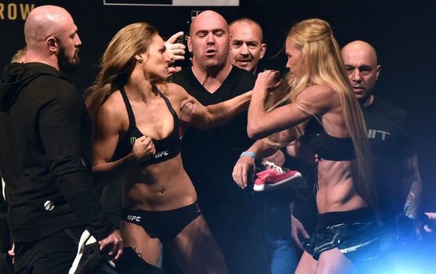 epa05023940 US MMA fighter Ronda Rousey (left) and US MMA fighter Holly Holm scuffle during a face-off after the weigh-in for their UFC bantam weight title fight at Etihad Stadium in Melbourne, Australia, 14 November 2015, ahead of their 15 November fight. EPA/JULIAN SMITH AUSTRALIA AND NEW ZEALAND OUT ORG XMIT: MLB